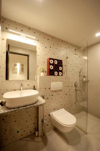 a bathroom with a sink and a toilet and a mirror at CasaKai 2BHK Bohemian Spread with 3 Patios & Pool, Near Thalassa in Siolim