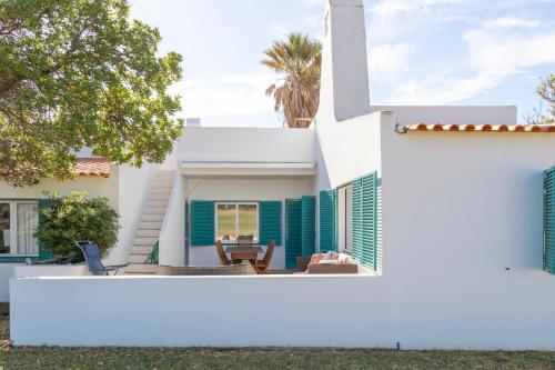 a white house with green shutters and a yard at Prainha Residences-A17 -Portimão in Alvor