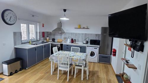 a kitchen with a table and chairs and a tv at WestCanyon Apartments in Faja Grande