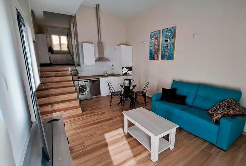 a living room with a blue couch and a table at Apartamento La Monina CUEVAS DEL VALLE in Cuevas del Valle