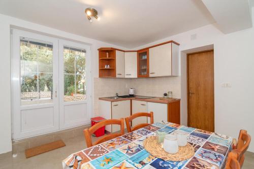a kitchen with a table with chairs and a dining room at Apartments Ip in Mandre
