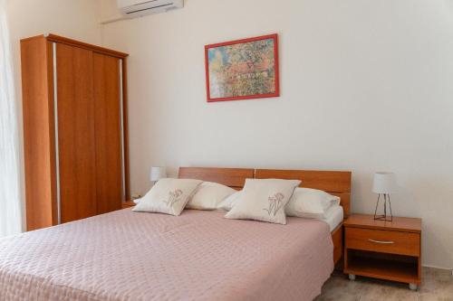 a bedroom with a bed and a picture on the wall at Apartments Ip in Mandre