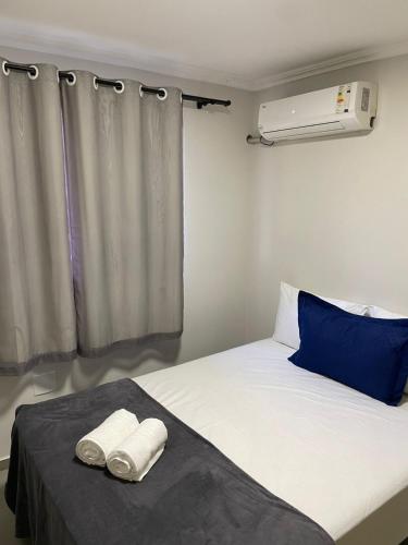 a bedroom with a bed with two towels on it at Apartamento 3 quartos, conforto e espaço no centro in Foz do Iguaçu