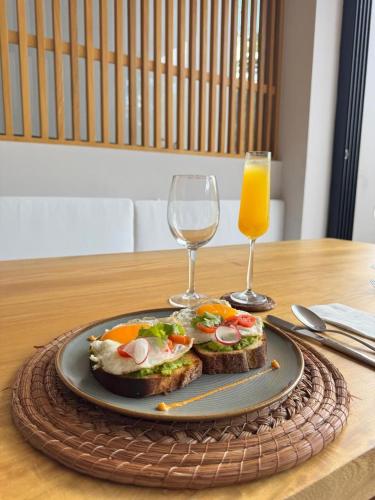 a plate of food on a table with two glasses of orange juice at Amaranto Bacalar Hotel Boutique in Bacalar