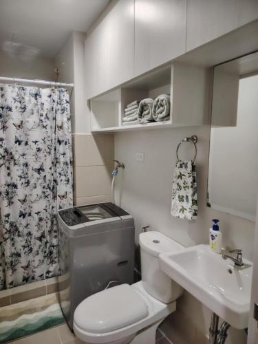 a small bathroom with a toilet and a sink at Charm Residences Building E in Manila