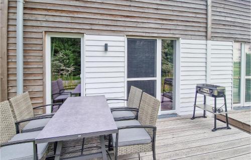 eine Terrasse mit Tisch und Stühlen auf einem Deck in der Unterkunft Puettenhuus in Tossenserdeich