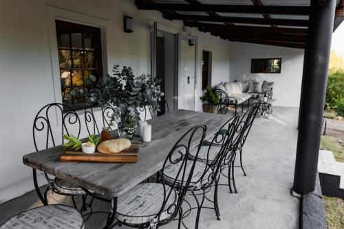 ein Holztisch und Stühle auf einer Terrasse in der Unterkunft Tara in Piketberg