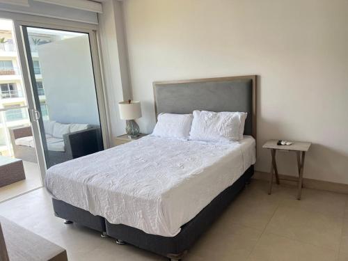 Un dormitorio con una cama y una mesa y una ventana. en Cartagena Serena del mar Morros IO, en Cartagena de Indias