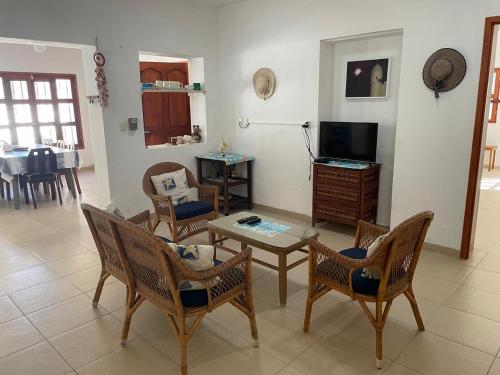 a living room with chairs and a table and a tv at Casa Jáal ja' in Sisal