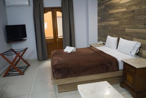 a hotel room with a bed and a television at Hotel Santiago De Compostela - Guadalajara Centro Historico in Guadalajara