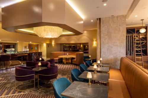 a restaurant with couches and tables and a chandelier at Rydges South Bank Brisbane in Brisbane