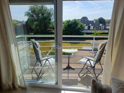a view from a balcony with two chairs and a table at Sun and Sea De Haan in De Haan