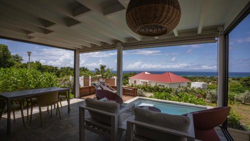 a patio with a pool and chairs and a table at Galanterie in Grand-Bourg
