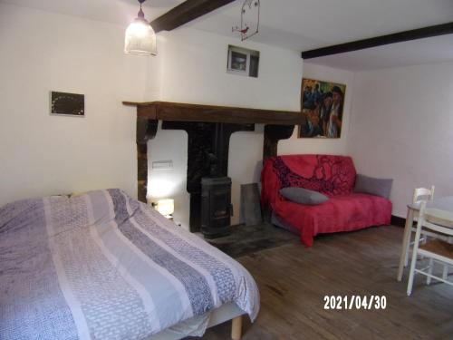 une chambre avec un lit et une chaise rouge dans l'établissement Le Vieux Plancher, à La Celle-sous-Gouzon