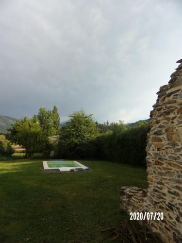 une cour avec une piscine et un mur en pierre dans l'établissement Le Vieux Plancher, à La Celle-sous-Gouzon