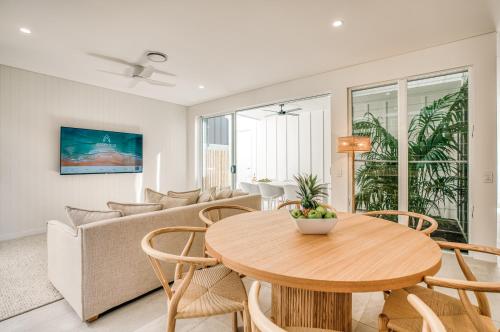 a living room with a table and a couch at Essence Peregian Beach in Peregian Beach