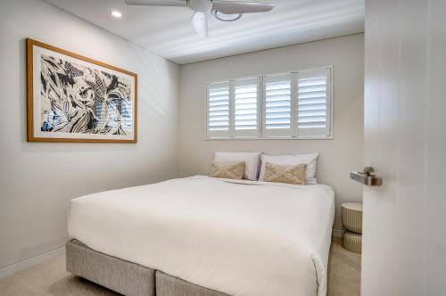a bedroom with a white bed and a window at Essence Peregian Beach in Peregian Beach