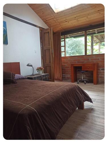 a bedroom with a bed and a desk and a fireplace at Confortable cabaña campestre in Ibarra