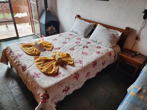 a bed with two bows on it in a bedroom at Pousada Cachyto de Cielo in Campos do Jordão