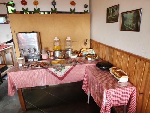 a table with a pink table cloth with food on it at Pousada Cachyto de Cielo in Campos do Jordão