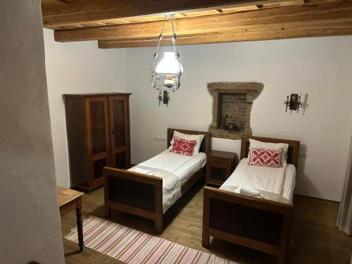 a bedroom with two beds and a chandelier at Castle View Saschiz - Traditional Guesthouse in Saschiz