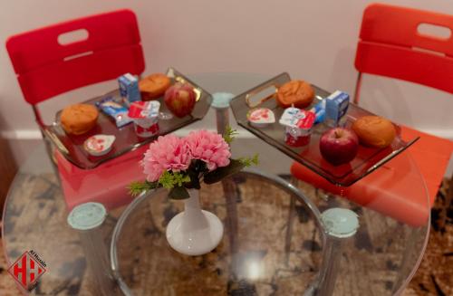 a table with two red chairs and a vase with flowers at فندق الحسين السياحي in Asyut