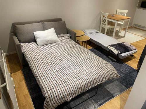 a living room with a bed and a table with a table at Lilla Skogsnära in Kolmården