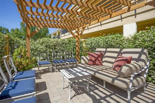 a patio with a couch and chairs under a wooden pergola at Best Western Plus Dixon Davis in Dixon