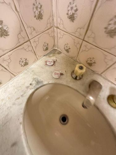 a white sink in a bathroom with floral wallpaper at GARVEY - JK APART Hotel in Brasilia