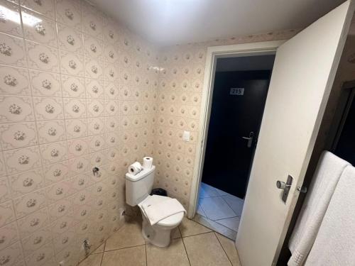 a bathroom with a white toilet in a room at GARVEY - JK APART Hotel in Brasilia