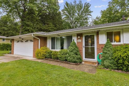 a brick house with a porch and bushes at CVNP Winter Getaway - 5 mins to Boston Mills Ski in Northfield