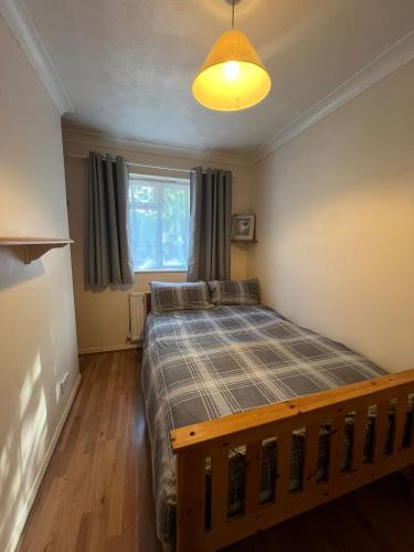 a bedroom with a bed and a large window at Spacious 4 bed Farnborough AirShow in Farnborough