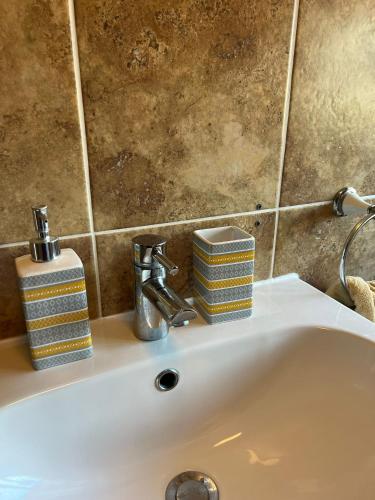 a bathroom sink with two soap dispensers on it at Spacious 4 bed Farnborough AirShow in Farnborough