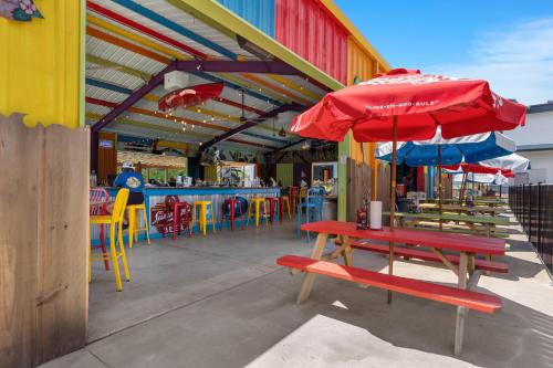 a colorful restaurant with a table and benches and umbrellas at Rock Lane Resort & Marina in Branson