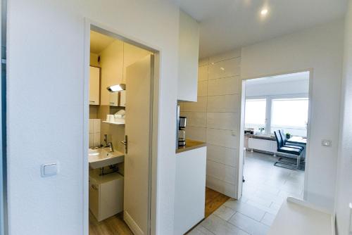 een kleine keuken met een wastafel en een badkamer bij Strandhochhaus SF11 in Cuxhaven