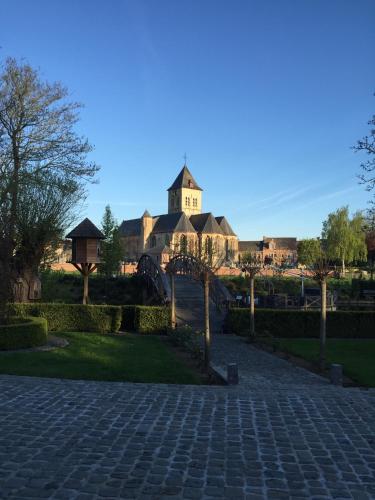 a building with a clock tower in the distance at B&B De Rentmeesterhoeve in Reningelst