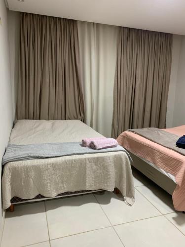 a bedroom with two beds and a window at Casa moderna e confortável 2andar in Leopoldina