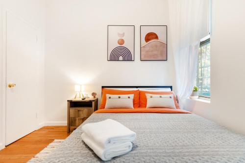 una camera bianca con un letto arancione e una finestra di Aura Style 3BD Suite at Times Square Manhattan a New York