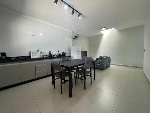 a kitchen with a table and chairs in a room at Casa de Lazer com piscina in Pirassununga