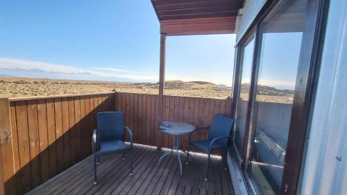 a balcony with two chairs and a table on a deck at Hekla Cabin 2 Volcano and Glacier View in Hella