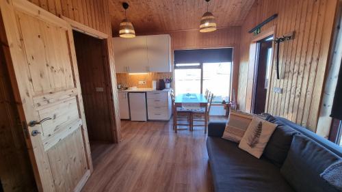 a living room with a couch and a kitchen at Hekla Cabin 2 Volcano and Glacier View in Hella
