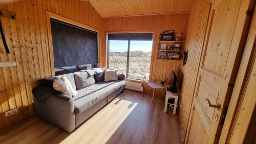 a living room with a couch and a large window at Hekla Cabin 2 Volcano and Glacier View in Hella