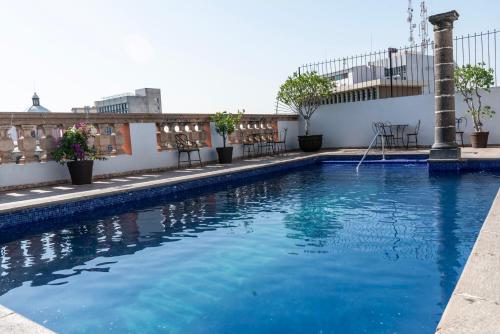 a swimming pool on the roof of a building at Hotel Santiago De Compostela - Guadalajara Centro Historico in Guadalajara