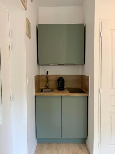 une cuisine avec des armoires bleues et un évier dans l'établissement Évasion spa près de Giverny, à Vernon