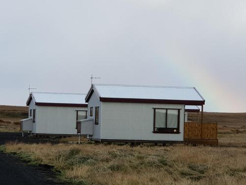 two small white houses in a field with a road at Hekla Cabin 3 Volcano and Glacier View in Hella
