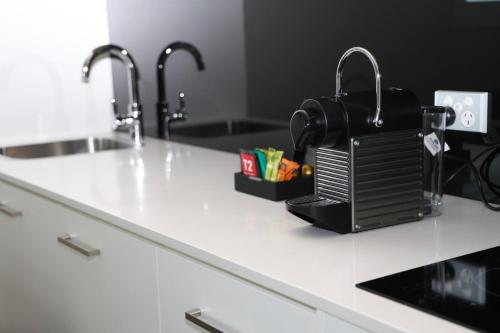 a kitchen counter with a sink and a coffee maker at Avenue Hotel Canberra in Canberra
