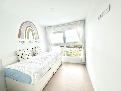 a white bedroom with a rainbow sticker on the wall at Luxury Canet in Canet de Berenguer