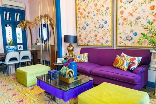 Una sala de estar con un sofá morado y una mesa en Stylish Colonial Townhouse in Santo Domingo's Historic Heart, en Santo Domingo