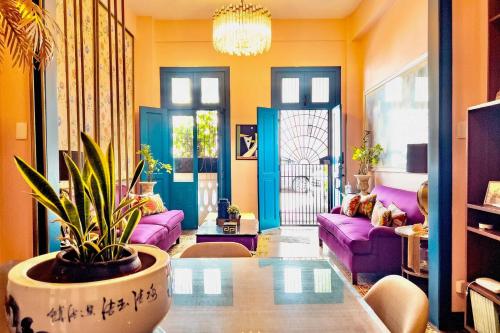 Una sala de estar con sofás morados y una planta. en Stylish Colonial Townhouse in Santo Domingo's Historic Heart, en Santo Domingo
