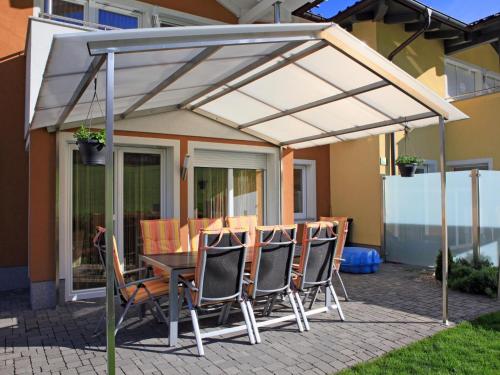 a patio with a table and chairs under a canopy at Ferienhaus Gartentraum 1 in Itter